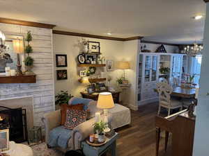 Living room with engineered hard wood, ornamental molding, and a notable chandelier