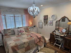 Bedroom with a notable chandelier, crown molding, and engineered hard wood