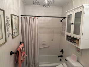 Full Bathroom featuring toilet, shower / bath combo with shower curtain, vanity, and ornamental molding