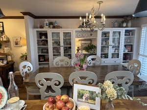 Dining room featuring crown molding, engineered hard wood, and a notable chandelier