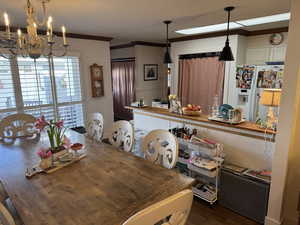 Dining space featuring engineered hard wood, an inviting chandelier, and ornamental molding