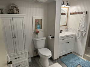 Bathroom featuring toilet, vanity, and shower right off the bedroom, could be a master suite.