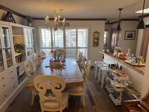 Dining room featuring crown molding, engineered hard wood, and an inviting chandelier