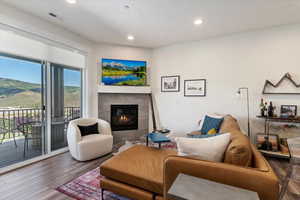 Living room featuring wood-type flooring and a tiled fireplace