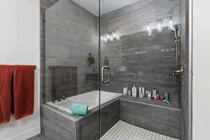 Bathroom featuring plus walk in shower and tile patterned flooring