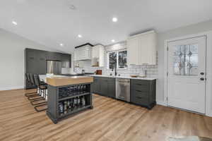 Open kitchen with light hardwood / wood-style floors, modern cabinetry and fixtures