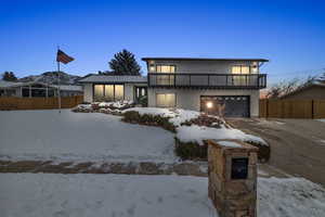 View of front of home featuring a balcony and a garage