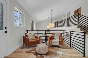 Sitting area featuring vaulted ceiling and light hardwood / wood-style floors