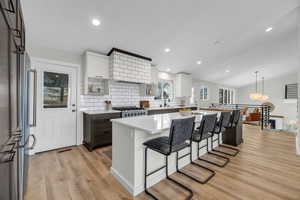 Open kitchen with light hardwood / wood-style floors, modern cabinetry and fixtures