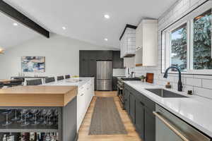 Open kitchen with extra large island, vaulted ceiling and modern finishes