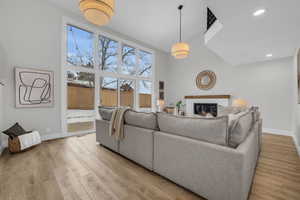 Living room featuring hardwood / wood-style floors, expansive windows, and a brick fireplace