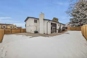 Snow covered property with central AC unit