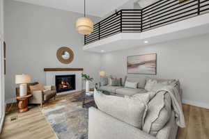 Living room featuring hardwood / wood-style floors, expansive windows, and a brick fireplace