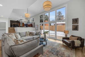 Living room featuring hardwood / wood-style floors, expansive windows, and vaulted ceiling