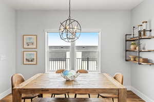 Dining area featuring wood-type flooring and an inviting chandelier