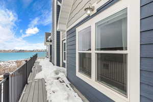 Snow covered back of property with a water view