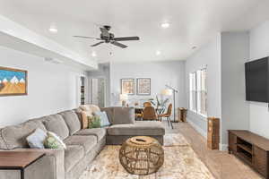 Living room featuring light carpet and ceiling fan