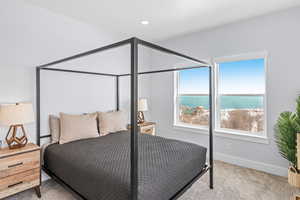 Bedroom with carpet and a water view