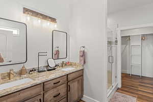 Bathroom with vanity, hardwood / wood-style floors, and a shower with door