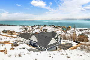 Snowy aerial view featuring a water view