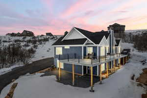 Snow covered back of property with a balcony