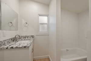 Bathroom featuring shower / tub combination, hardwood / wood-style floors, and vanity