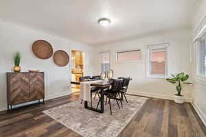 Dining space with a healthy amount of sunlight, dark hardwood / wood-style floors, and ornamental molding