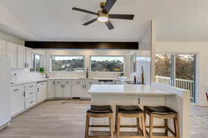 Kitchen featuring a kitchen breakfast bar, white cabinets, and kitchen peninsula