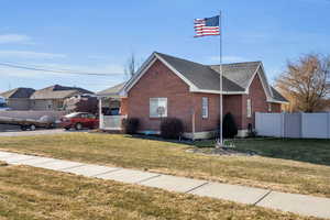 View of front of house with covered porch and a front yard