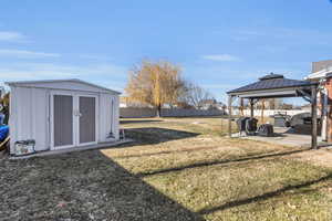 View of yard with a patio area, a gazebo, and a storage shed