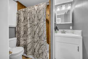 Bathroom featuring toilet, ornamental molding, hardwood / wood-style floors, and walk in shower