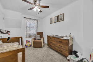 Carpeted bedroom featuring ceiling fan and ornamental molding