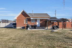 Rear view of property with a gazebo and a lawn