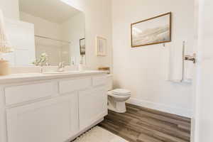 Bathroom featuring toilet, vanity, and hardwood / wood-style flooring