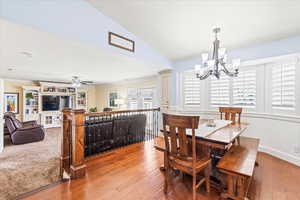 Dining room featuring wood-type flooring and ceiling fan with notable chandelier