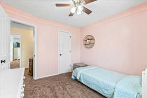 Carpeted bedroom featuring ceiling fan