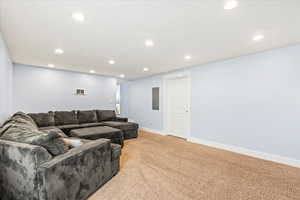 Living room featuring light carpet and electric panel