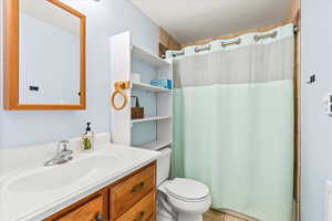 Bathroom featuring toilet, tile patterned floors, and vanity