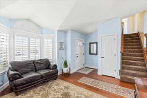 Living room with hardwood / wood-style flooring and lofted ceiling