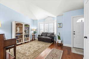 Interior space with lofted ceiling and dark hardwood / wood-style floors