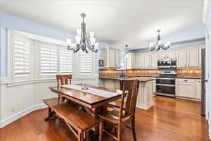 Dining area featuring vaulted ceiling, a chandelier, light wood-type flooring, and sink