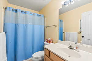 Bathroom with toilet, vanity, and walk in shower