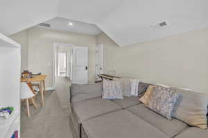 Carpeted living room with lofted ceiling