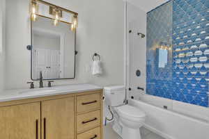 Full bathroom featuring washtub / shower combination, vanity, toilet, and tile patterned flooring