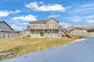 Rear view of property with a patio area, a deck with mountain view, and a lawn