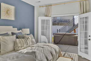 Bedroom with light colored carpet and french doors