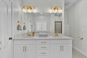 Bathroom featuring vanity, tile patterned floors, and an enclosed shower