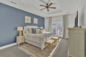 Bedroom with ceiling fan, carpet, access to exterior, a tray ceiling, and french doors