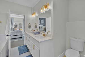 Bathroom with toilet, tile patterned flooring, french doors, and vanity