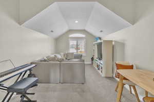 Living room featuring light colored carpet and vaulted ceiling